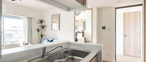 Una cucina moderna con lavello in acciaio inossidabile, mobili in legno e vista sull'esterno.