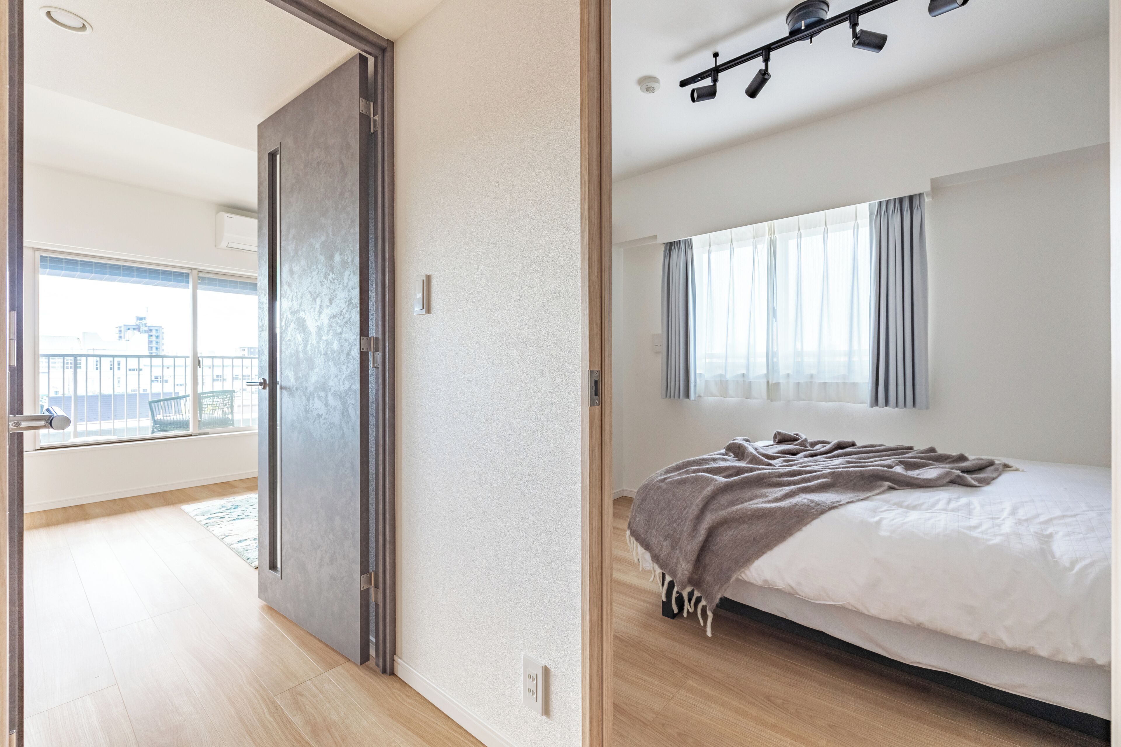 A bedroom with a bed, a window with curtains, and a view of the outside.