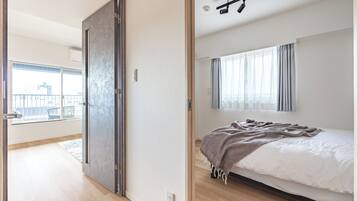 A bedroom with a bed, a window with curtains, and a view of the outside.