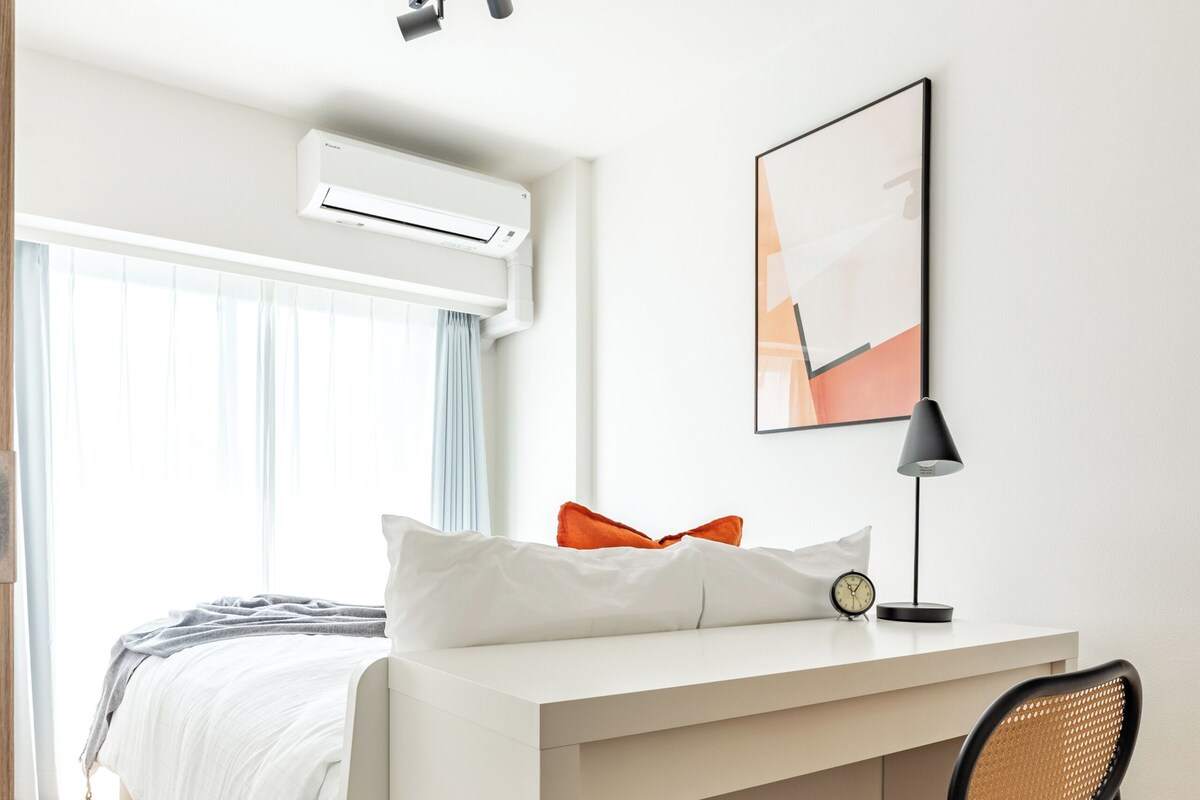 A modern bedroom with a bed, a desk, and a chair.