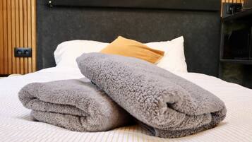 A neatly made bed with folded towels, a pillow, and a headboard.