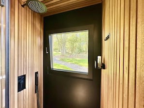 Een houten deur met een raam, een handgreep en een klein plankje met spullen.