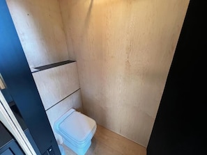 A small, narrow bathroom with a toilet and a trash bin. - Romantic Tiny House in the Belgian Ardennes (Ferrières)