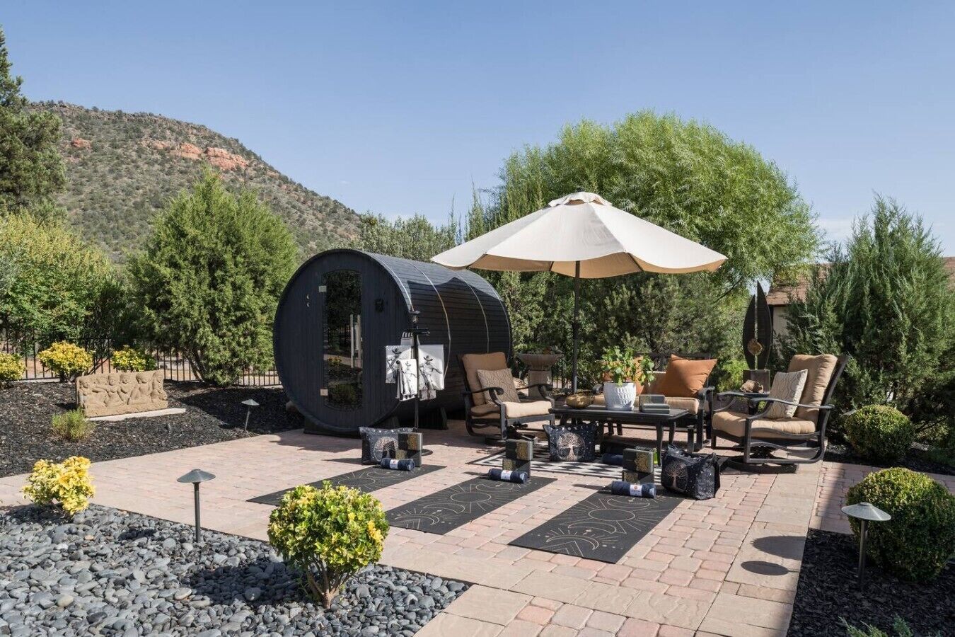 Une terrasse extérieure avec un tonneau, des sièges et un grand parasol.