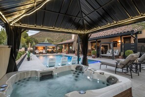 A pool area with a hot tub, lounge chairs, and a covered patio. - Desert Bloom - Heated Pool & Spa, Sauna, Gym, Game Room (Sedona)
