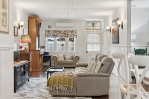 A spacious living room with a sofa set, a coffee table, and a patterned rug.