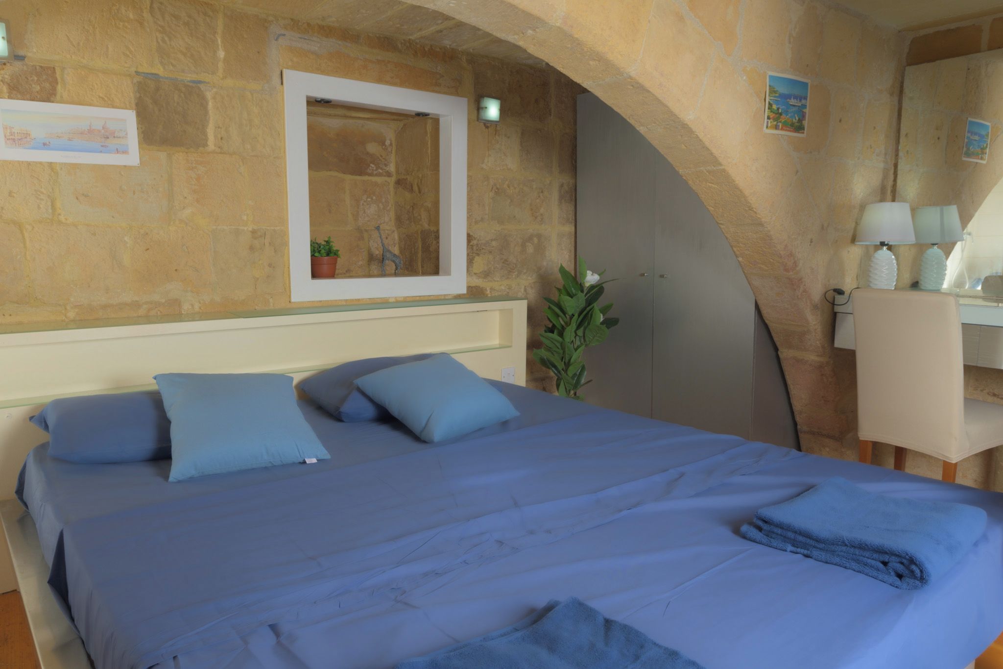 Un dormitorio con una cama grande, un escritorio y una silla.