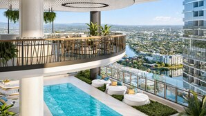 Área de piscina no terraço, com vista para a paisagem urbana, cercada por vegetação e assentos modernos.