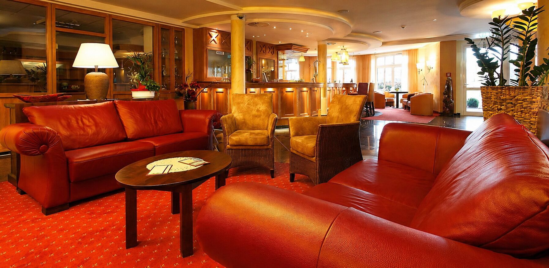 A lobby with leather sofas, a bar area, and a reception desk.