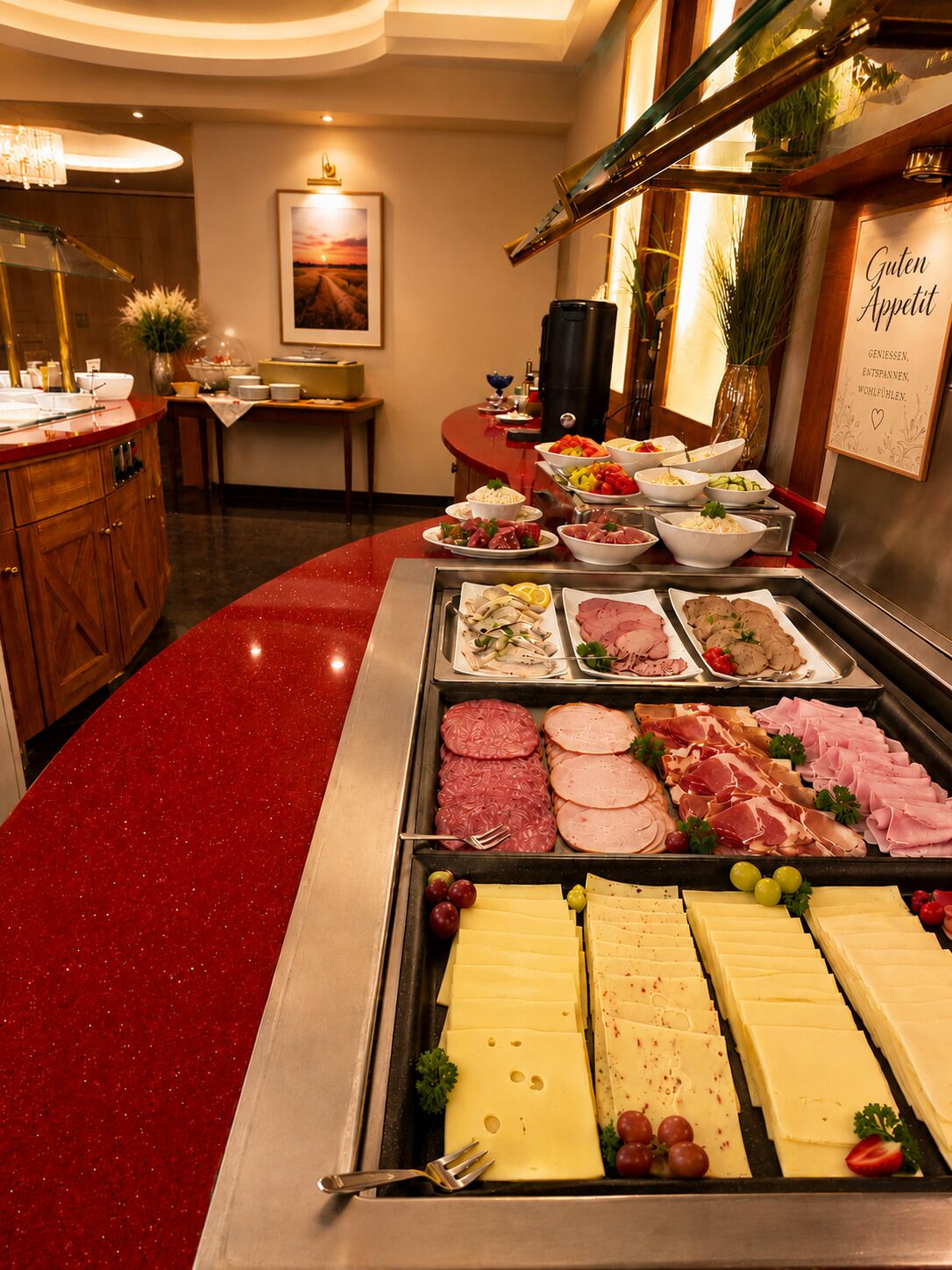 A buffet with various meats and cheeses, a chandelier, and a framed picture on the wall.