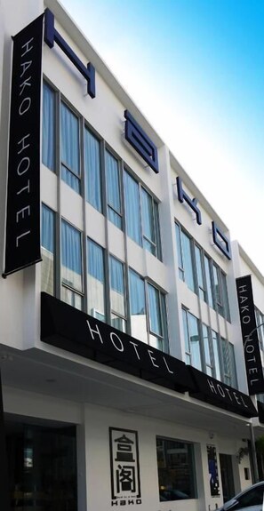 A modern hotel building with a prominent sign reading 'HAKO HOTEL' and a logo below.
