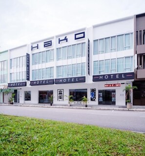 Un hotel de varios pisos con fachada moderna, ventanas grandes y un letrero que indica que es un hotel.