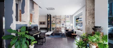 Una sala de estar moderna con un piano, zona de estar y un ventanal con vistas a la calle.