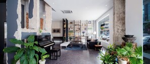 A modern living room with a piano, seating area, and a large window with a view of the street.