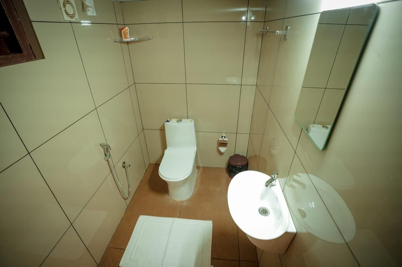Un baño pequeño con inodoro, lavamanos y ducha.