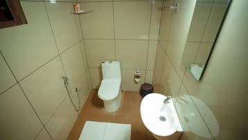 Un baño pequeño con inodoro, lavamanos y ducha.