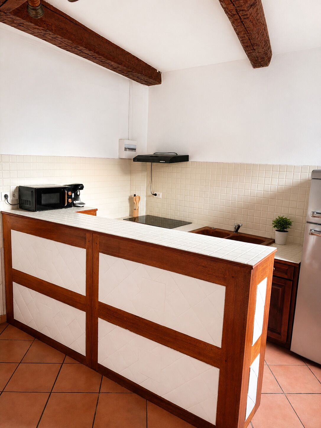 A kitchen with a central island, a microwave, a coffee maker, and a sink.