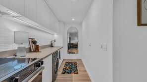 Eine moderne Küche mit integriertem Backofen, Mikrowelle und Kaffeemaschine.