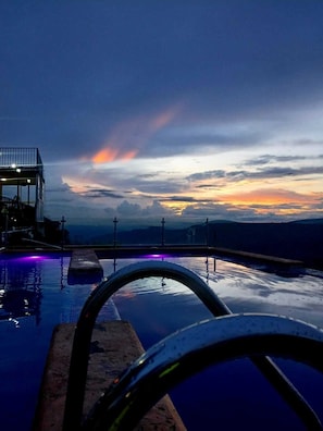 A swimming pool with a view of the sunset and mountains in the background. - Vrbo Property (Tonalá)