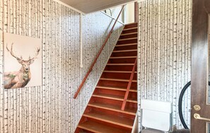 Una escala de fusta amb barana metàl·lica que condueix a un aterri.