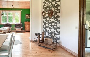 Habitació amb llar de foc, mobles de fusta i paret verda.