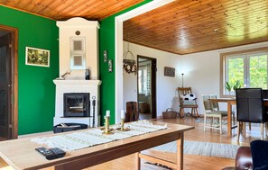 A room with a fireplace, a dining table, and a view of the outdoors. - Awesome home in Lammhult with WiFi (Lammhult)