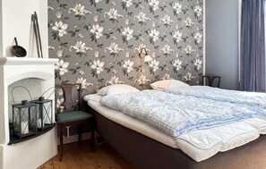 A bedroom with a bed, a nightstand, a lamp, a chair, and a fireplace. - Awesome home in Lammhult with WiFi (Lammhult)