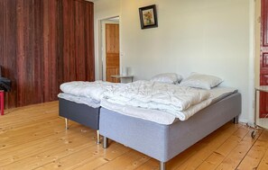 Un dormitori amb un llit, una nitzeta i un armari de fusta.