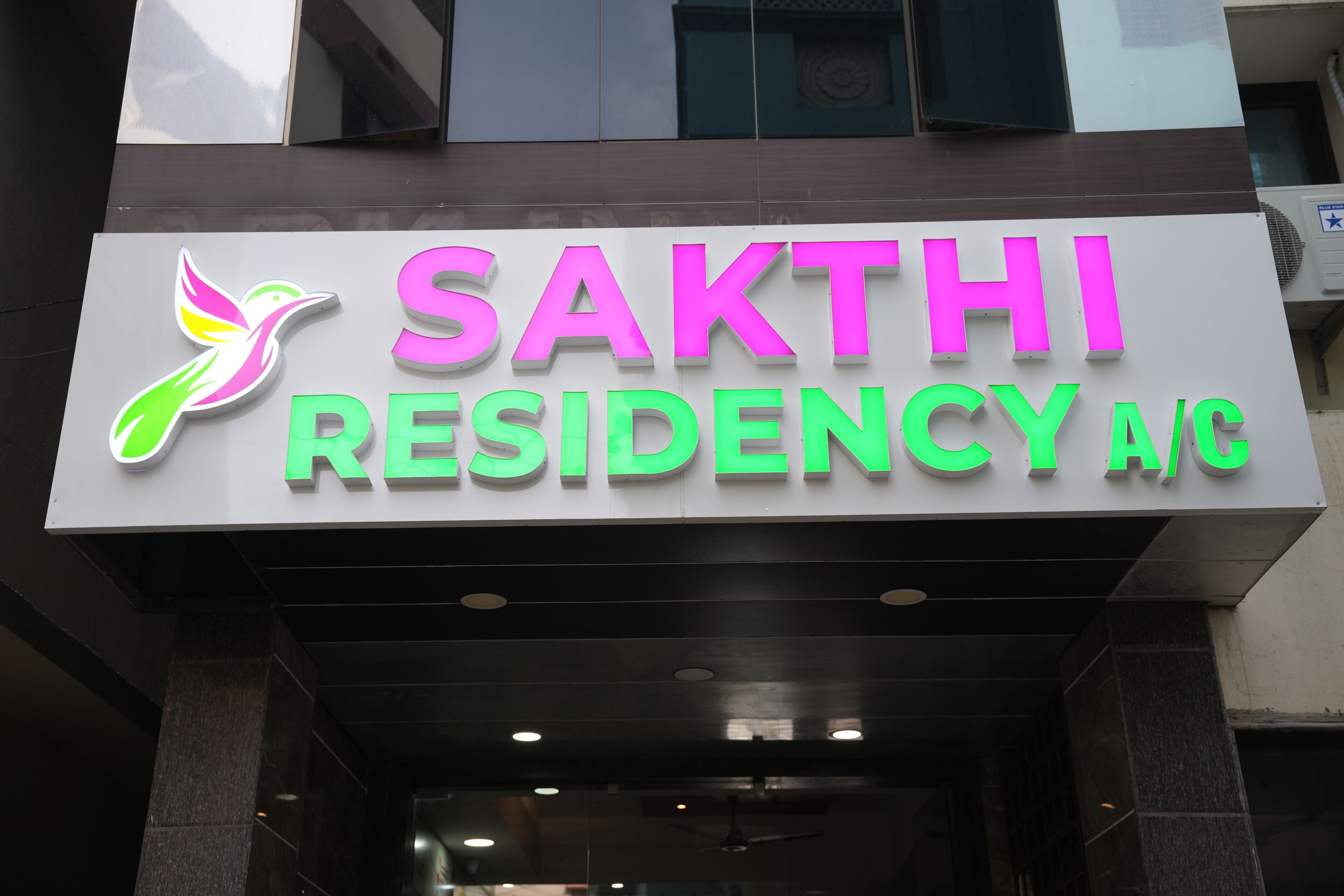 Schild für 'SAKTHI RESIDENCY AC' mit stilisierter Vogel-Logo.