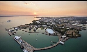 An aerial view of a coastal city with a marina, a large stadium, and a dense urban area. - Darwin CBD Studio with Work Area (Darwin City)