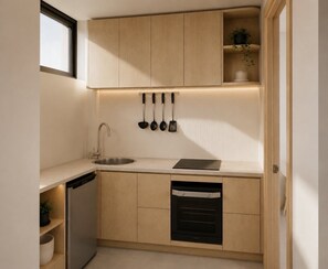A compact kitchen with a built-in dishwasher, a sink, and a stove. - Darwin CBD Apartment with BBQ Facilities (Darwin City)