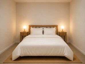 A bedroom with a large bed, two bedside tables with lamps, and a wooden headboard. - CBD Darwin 1-Bed Stay with Free Parking (Darwin City)
