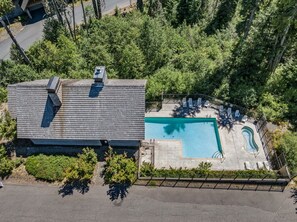 Ein Wohnhaus mit Swimmingpool, überdachter Terrasse und umzäunter Garten.