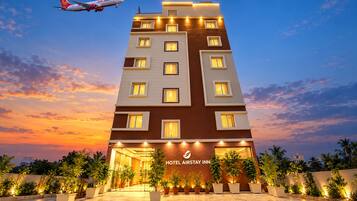 A multi-story hotel with a modern design, featuring a prominent entrance and a sign indicating it is the 'HOTEL AIRSTAY INN'.