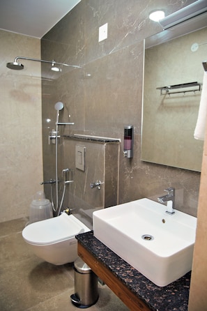 A modern bathroom with a shower, toilet, and sink. - Hotel Airstay Inn (Bandikodegehalli Amanikere)