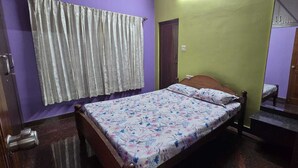 Une chambre à coucher avec un lit, des rideaux, une porte et un petit banc.
