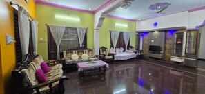 Un salón amplio con un conjunto de sofás, una mesita de centro y un televisor.