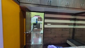 Una habitación con suelo de madera, una cama y un armario con varios compartimentos.