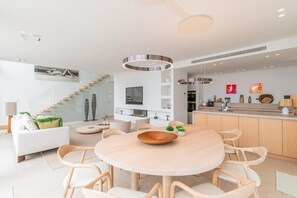 A modern kitchen with a central island, wooden chairs, and a dining table. - Villa Llum de Mar - Benissa, Costa Blanca (Benissa)
