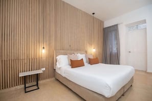 A bedroom with a bed, bedside tables, and a wall with vertical wooden slats. - Luxury Room in Casa Escallon (Cartagena)