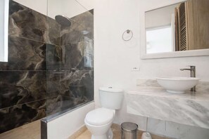 A bathroom with a glass-enclosed shower, a white toilet, and a marble sink. - Luxury Room in Casa Escallon (Cartagena)