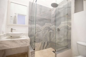 A bathroom with a glass-enclosed shower, a white sink, and a toilet. - Luxury Room in Casa Escallon (Cartagena)