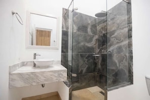 A bathroom with a white sink, a glass shower enclosure, and a mirror above the sink. - Luxury Room in Casa Escallon (Cartagena)
