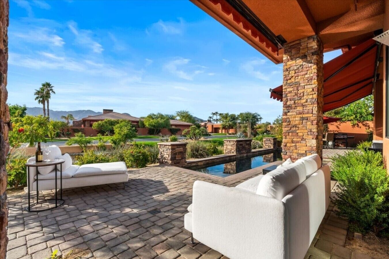 Eine Terrasse mit Gartenmöbeln, einem Schwimmbad und Blick auf eine Wohngegend.