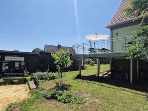 Un pati amb una cafeteria, mobiliari exterior i una petita zona de jardí.