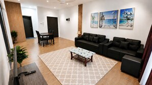 A modern living room with a sofa, a coffee table, and a dining area with chairs and a table.