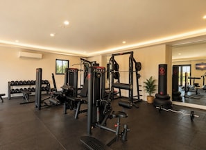 Een sportschool met diverse fitnessapparaten, waaronder krachttoestellen en gewichten.