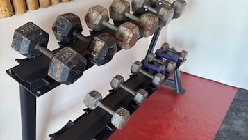 A set of adjustable dumbbells on a rack with a red and black floor.