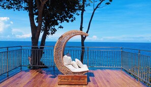 A wooden deck with a wicker chair and a sign that reads 'Scabrue Haven Resort.' - Seabreeze Haven Resort (Maria)