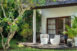 A house with a porch, two wicker chairs, a potted plant, and a large window. - Private Pool | Garden Lounge | Dedicated Workspace (Canggu)
